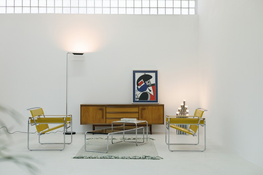 Modern living room with yellow armchairs and abstract art.
